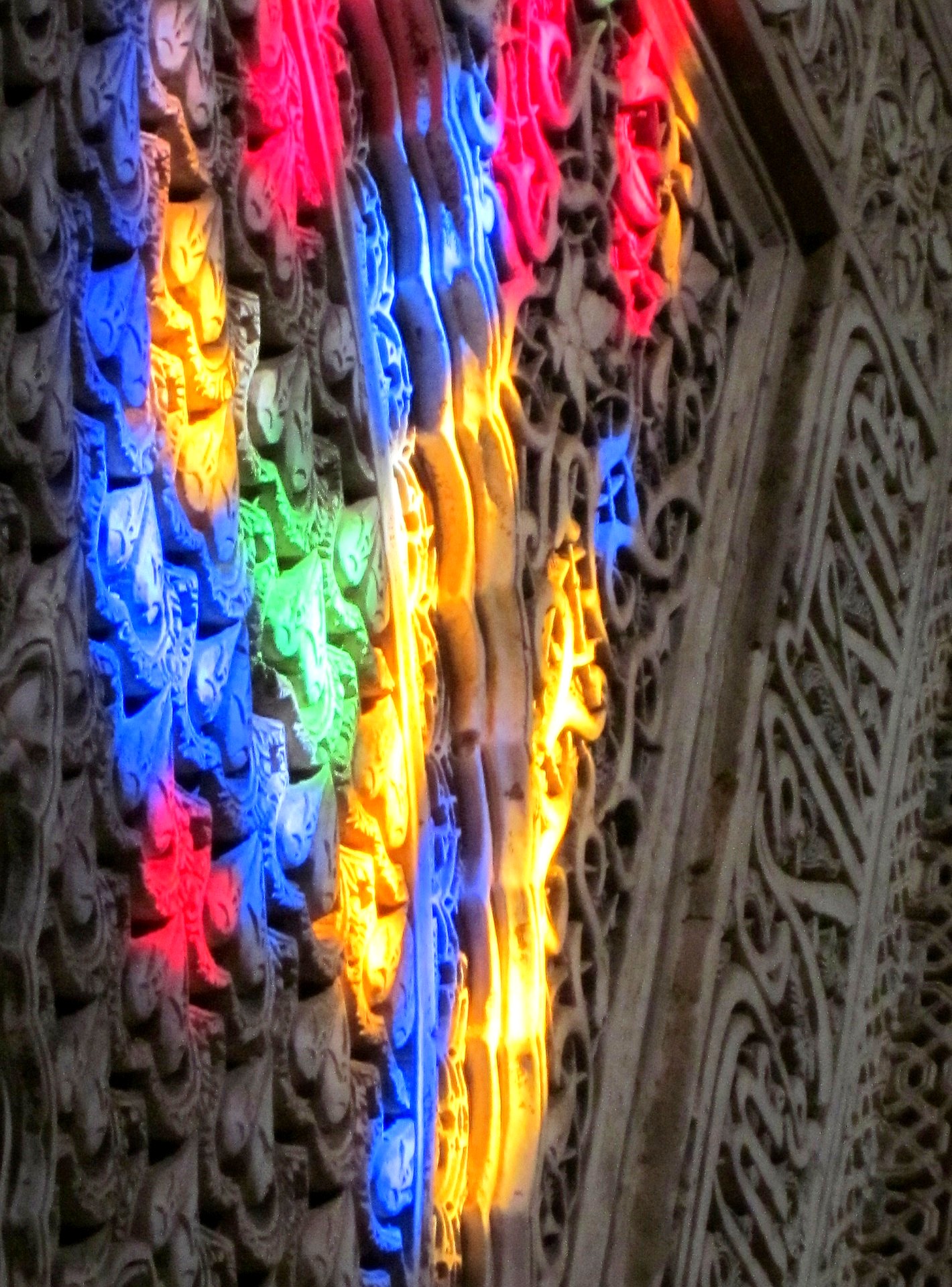 reflection of stained glass window on wall of cathedral