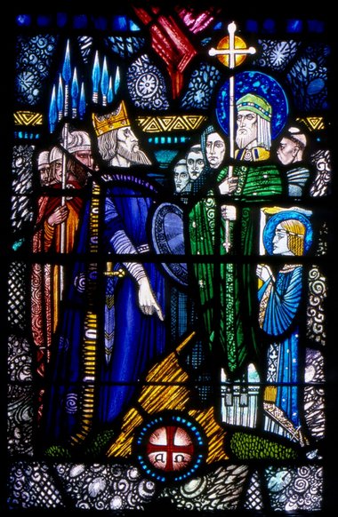 Harry Clarke stained glass window of St. Patrich holding cross before king