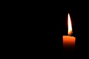 single candle shining in darkness