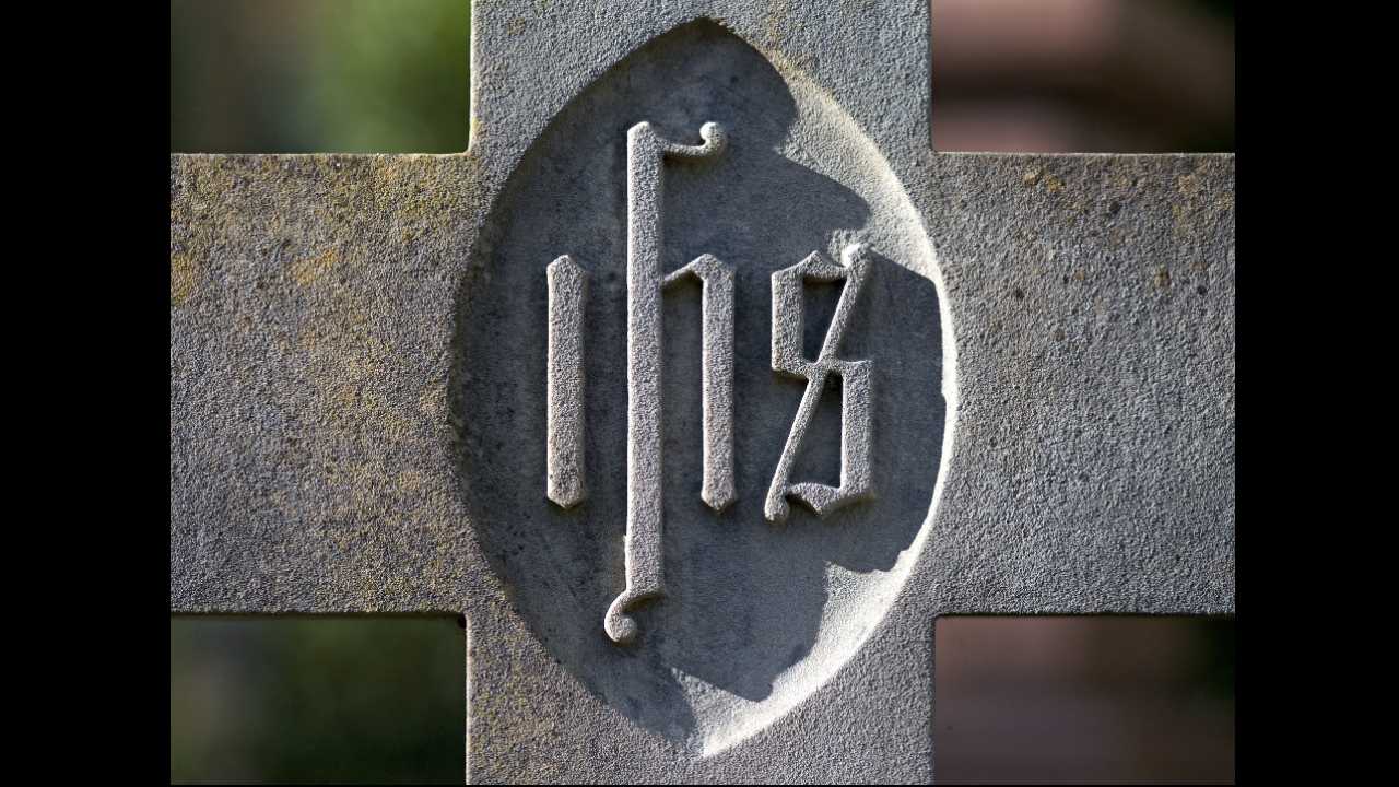 stone cross with IHS engraved on it